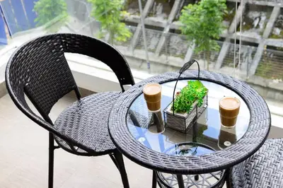 a wicker table and chairs with cups and a plant at Serene Mossy Family Cottage(2-7pax) 10 Min to BOH in Cameron Highlands