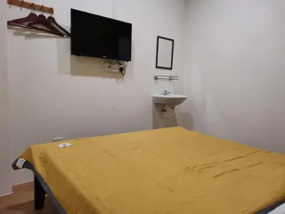 a room with a bed and a flat screen tv at G FORTUNE HOTEL + in George Town
