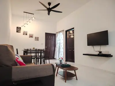 a living room with a couch and a flat screen tv at Samudera Seri Manjung Residences by Manhattan Group in Kampong Pundut