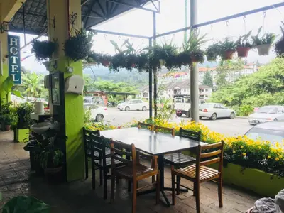 a table and chairs in a restaurant with a view of a street at Lily Haven Hotel C-1 in Tanah Rata