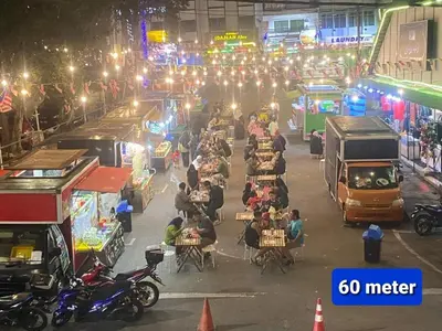 a busy street at night with people sitting at tables at Emerald New Homstay in Brinchang