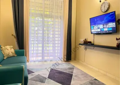 a living room with a tv and a couch and a clock at Anoi Homestay TAMBUN @ Lost World HighSpeed WiFi in Tambun