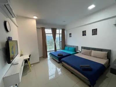 a bedroom with a blue bed and a television at GR studio APARTMENT 1 - kompleks MUTIARA gua MUSANG in Gua Musang