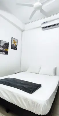 a bedroom with a white bed with a ceiling fan at Minimaliste Ipoh Garden 2 minute to stadium 5BR5BR in Ipoh