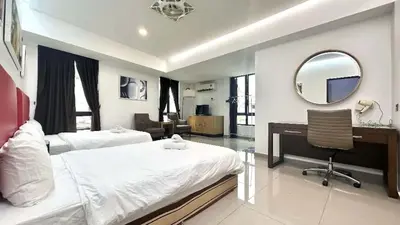 a bedroom with two beds and a desk and a mirror at Jovial Boutique Hotel```` Kampung Baru in Bukit Mertajam