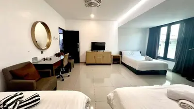 a hotel room with two beds and a mirror at Jovial Boutique Hotel```` Kampung Baru in Bukit Mertajam