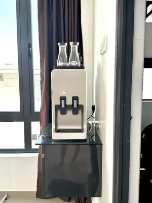 a table with a toaster and two vases on it at Jovial Boutique Hotel```` Kampung Baru in Bukit Mertajam