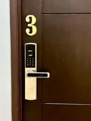 a wooden door with a remote control on it at Jovial Boutique Hotel```` Kampung Baru in Bukit Mertajam