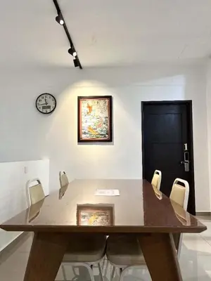 a dining room table with chairs and a clock on the wall at Jovial Boutique Hotel```` Kampung Baru in Bukit Mertajam