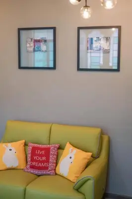 a green couch with pillows on it in a room at MODERN HERITAGE HOUSE``````Georgetown\u4e54\u6cbb\u5e02 in George Town