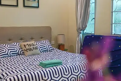 a bed with black and white sheets and pillows at MODERN HERITAGE HOUSE``````Georgetown\u4e54\u6cbb\u5e02 in George Town