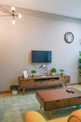 a living room with a flat screen tv on a wall at MODERN HERITAGE HOUSE``````Georgetown\u4e54\u6cbb\u5e02 in George Town