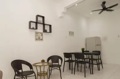 a dining room with chairs and a table and a refrigerator at WY Impian Homestay in Bukit Mertajam