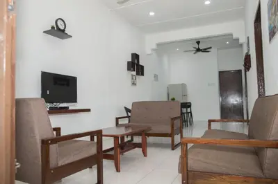 a living room with chairs and a table and a tv at WY Impian Homestay in Bukit Mertajam