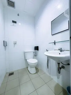 a white bathroom with a toilet and a sink at Asia Green Hotel in Sungai Besar