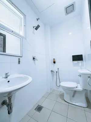 a white bathroom with a toilet and a sink at Asia Green Hotel in Sungai Besar