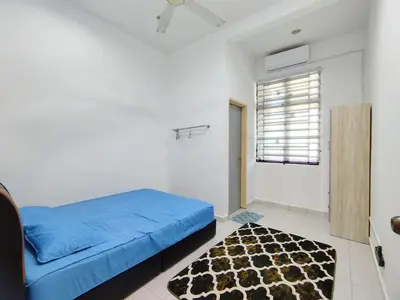 a bedroom with a blue bed and a rug at Indah Damai Homestay in Kepala Batas