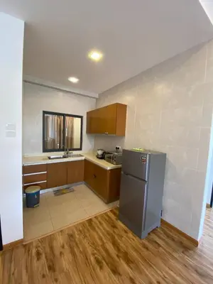 a kitchen with a stainless steel refrigerator and wooden cabinets at Delisha Homestay 3R2B The Retreat,Aranda Nova in Brinchang