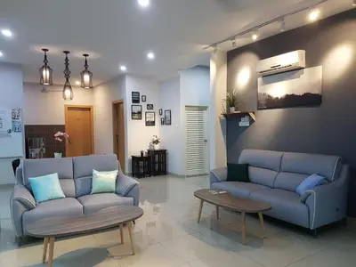 a living room with two blue couches and a table at White House Homestay in Ipoh