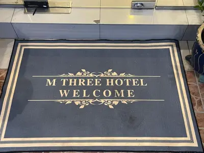 a sign for a hotel welcome mat on a table at M Three Hotel in Kampong Batu Tiga
