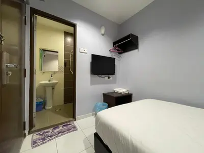 a bedroom with a bed and a shower and a sink at M Three Hotel in Kampong Batu Tiga