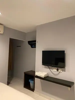 a room with a flat screen tv on a wall at M Three Hotel in Kampong Batu Tiga