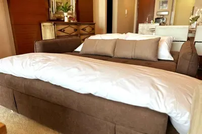 a large bed with white sheets on top of it at Straits Quay Highest & Spacious Seaview Suite - 2 in Tanjong Tokong