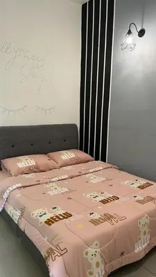 a bedroom with a bed with a pink comforter at Sweet Homestay 3RM @ Penthouse Apartment in Brinchang in Brinchang