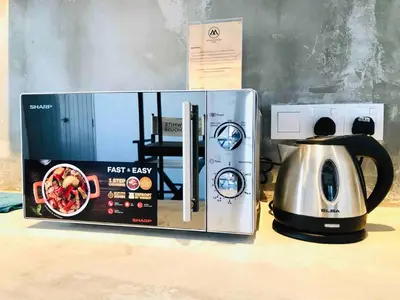 a microwave and a tea kettle on a table at INS White House Ipoh in Ipoh