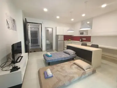 a living room with two beds and a kitchen at Deluxe Suites 5, 2-4 pax , Netflix, Georgetown in Jelutong