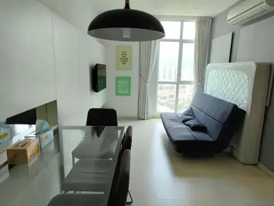 a living room with a couch and a glass table at Strait Garden Family Suites by Maj in Jelutong