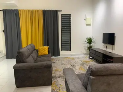 a living room with two couches and a television at Juwita&Arjuna Homestay Teluk Senangin in Kampong Batu Tiga