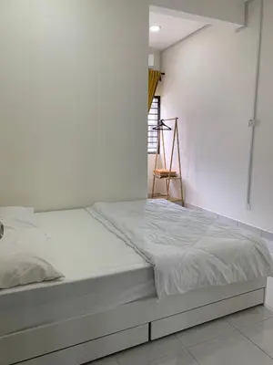 a bed in a room with a white wall at Juwita&Arjuna Homestay Teluk Senangin in Kampong Batu Tiga