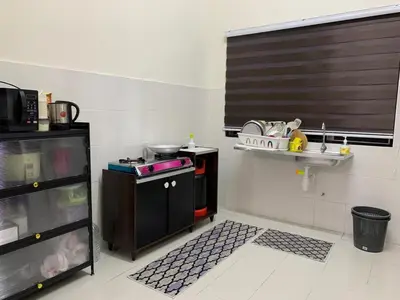 a small kitchen with a stove and a shelf at Juwita&Arjuna Homestay Teluk Senangin in Kampong Batu Tiga