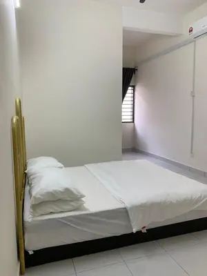 a bedroom with a bed with white sheets and a window at Juwita&Arjuna Homestay Teluk Senangin in Kampong Batu Tiga