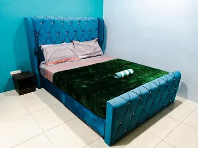 a bed with a blue bed frame with a bottle on it at Marvelous Homestay SP Kedah in Sungai Petani