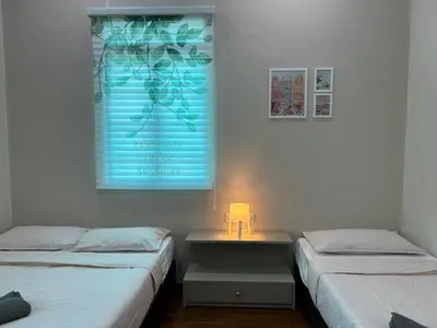 a room with two beds and a table with a lamp at myRoom Georgetown, Off Jalan Burma, Gurney Drive in George Town