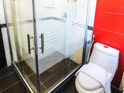 a bathroom with a toilet and a glass shower at K Garden Hotel Parit Buntar in Parit Buntar