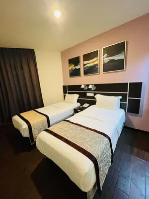 a hotel room with two beds in a room at K Garden Hotel Parit Buntar in Parit Buntar