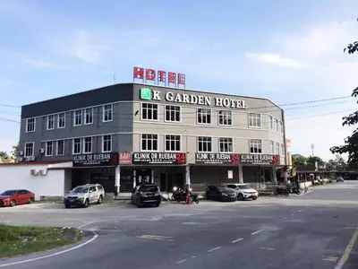 a hotel with cars parked in a parking lot at K Garden Hotel Parit Buntar in Parit Buntar