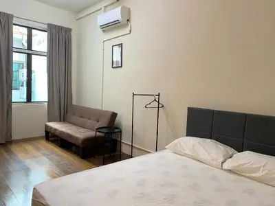 a bedroom with a bed and a chair and a window at Aayu Chulia - Chulia St, George Town in George Town