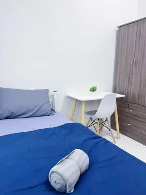 a bed with a blue blanket and a table and a chair at TheSun #3BR #PISA #FTZ #FamilyStay #USM in Bayan Lepas