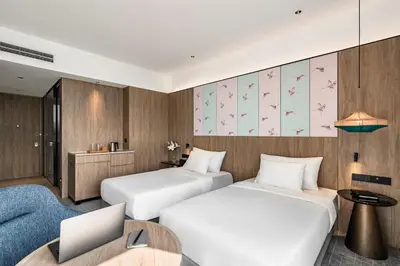 a hotel room with two beds and a desk with a laptop at Crowne Plaza Penang Straits City by IHG in Perai