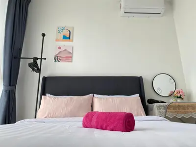 a bed with a pink towel on top of it at Urban Suites Georgetown, Penang in Jelutong