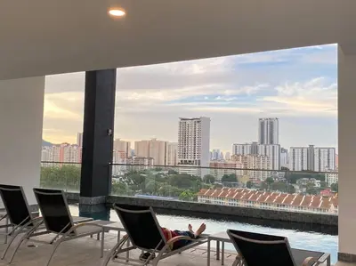 a person sitting in a chair on a building overlooking a city at Urban Suites Georgetown, Penang in Jelutong