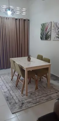 a wooden table and chairs in a living room at Ain's Homestay Muslim friendly Kuala Kubu Bharu in Kuala Kubu Baharu