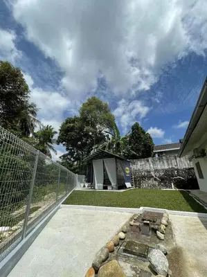 a backyard with a fire pit and a fence at Kiri Kanan Bukit Homestay Kuala Kubu Bahru \u5de6\u6797\u53f3\u820d in Kuala Kubu Baharu