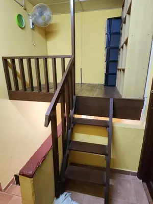 a wooden staircase with a chair in a room at Reyza Homestay KKB in Kuala Kubu Baharu