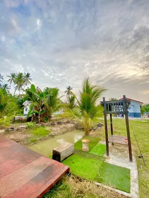 a wooden bench sitting on top of a grass field at Homestay Naim Sabak Bernam in Sabak Bernam