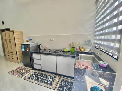 a kitchen with a sink and a refrigerator at Rumah Inap Che'Gu Baha in Teluk Intan
